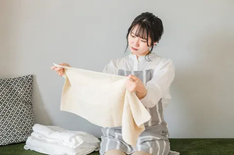 タオルの悪臭に顔をしかめる女性